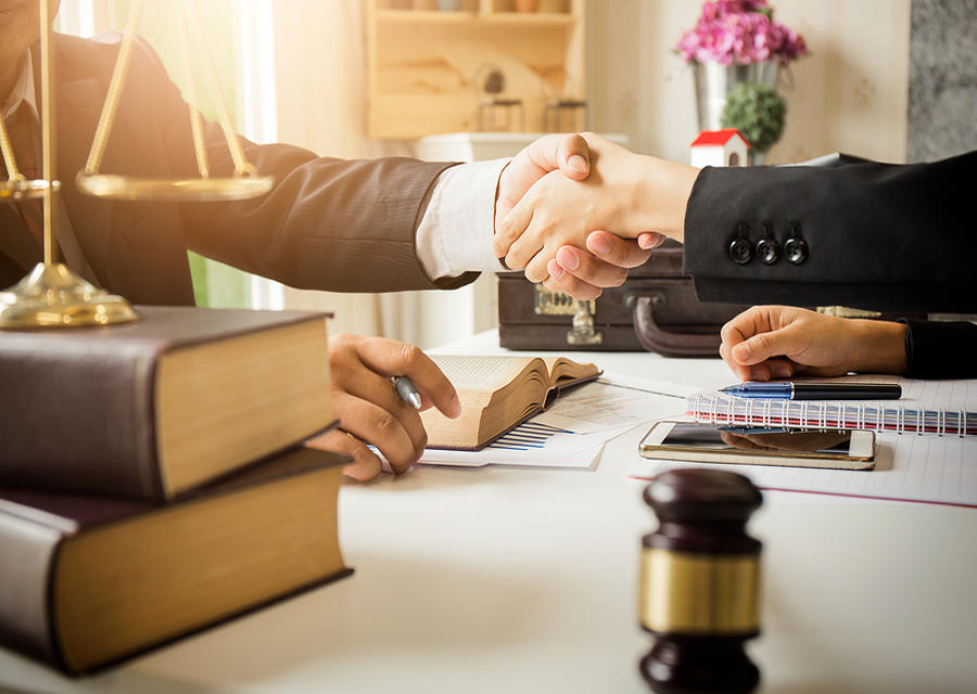 Lawyer and client shaking hands over desk